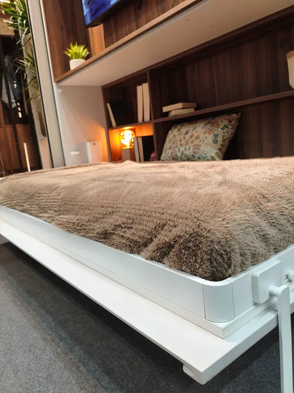 Cama plegable integrada en un mueble con estanterías y televisión